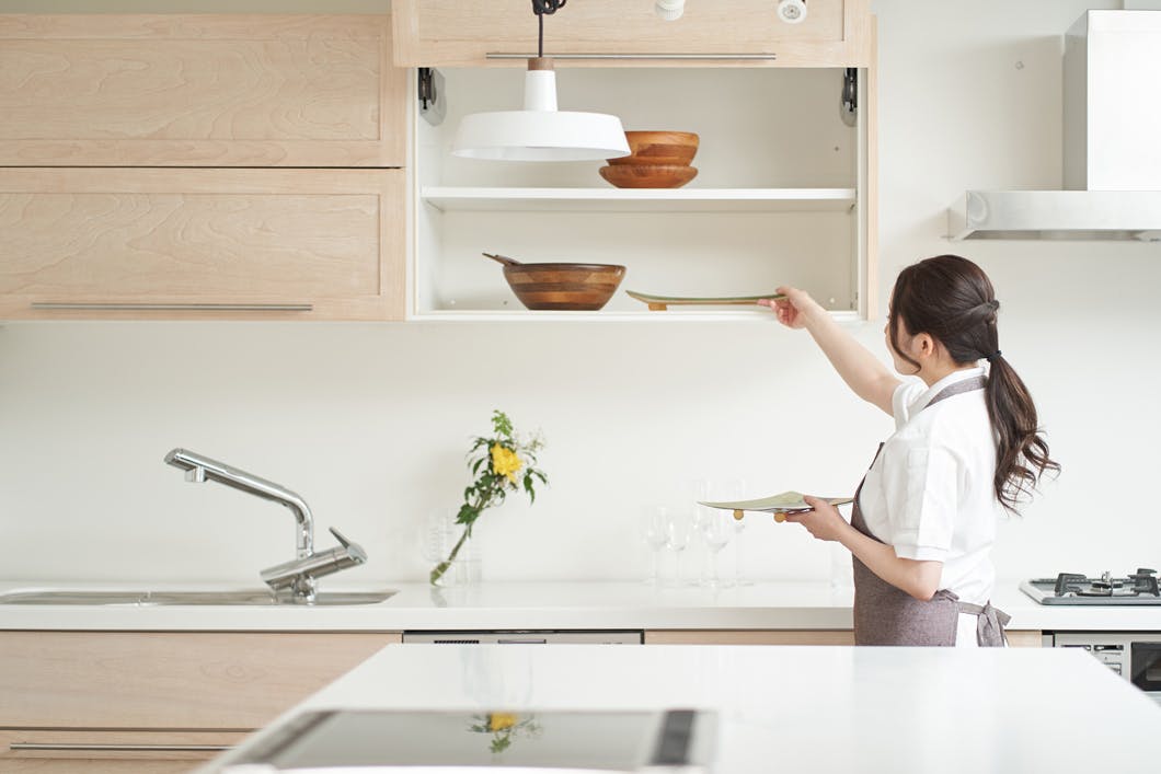 Professional cleaner organising the kitchen