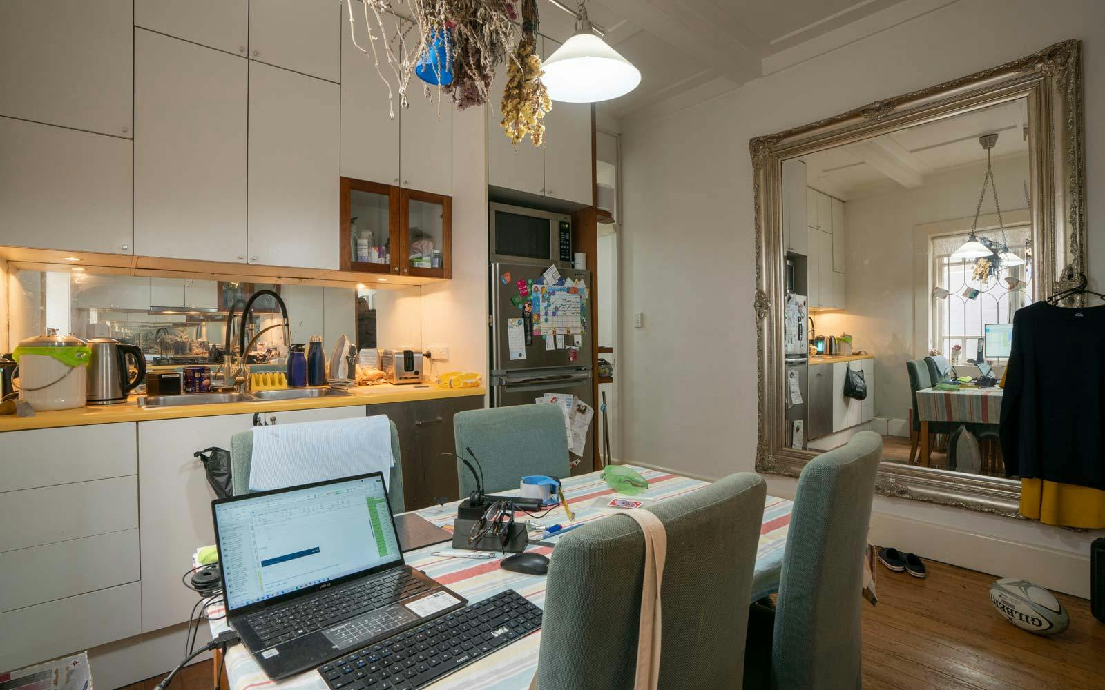 Small cluttered kitchen that is also being used as a home office
