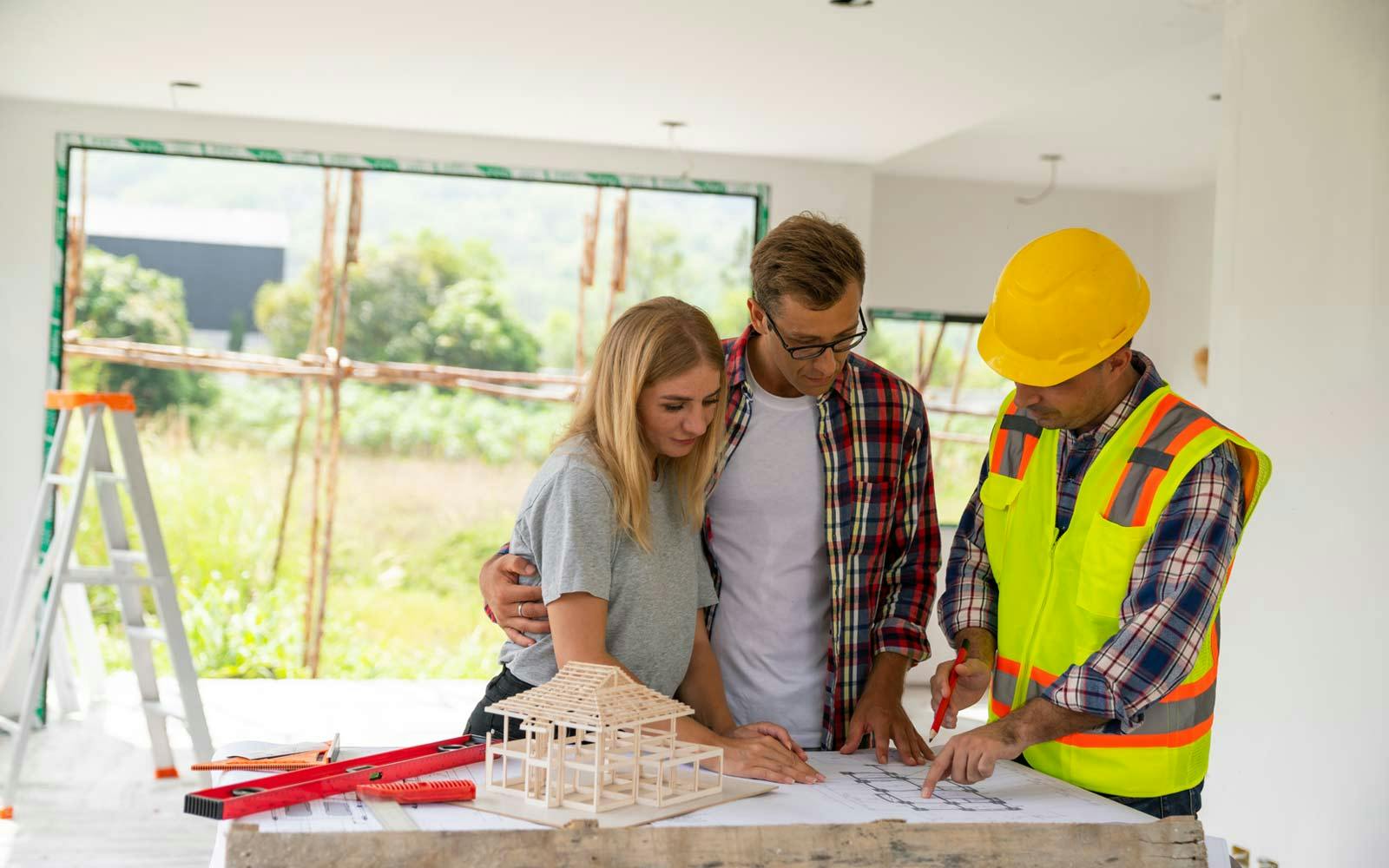 A couple looking at their home improvement project plans with their builder
