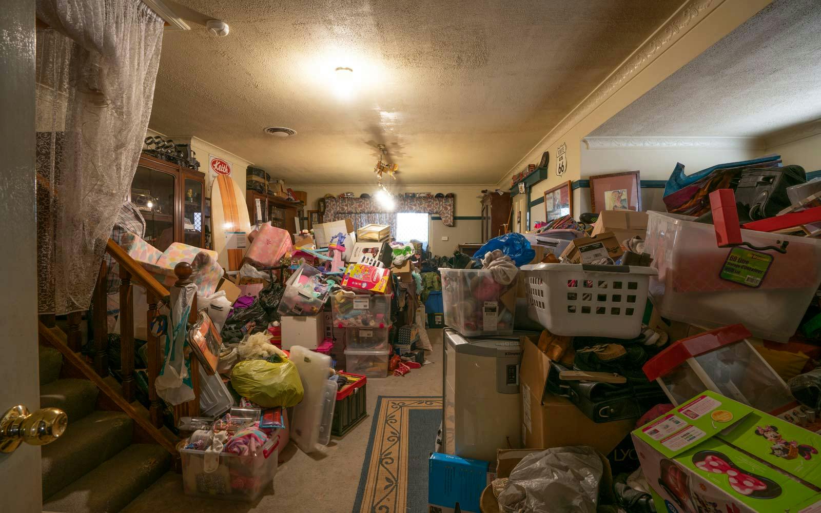 Cluttered rumpus room piled high with toys, clothes and shoes